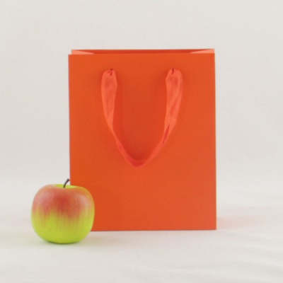 Пакеты бумажные 19х23х9см, цвет - оранжевый, материал - мелованная бумага, ламинация - матовая, ручки - лента хлопковая (киперная), фото 1 (вид спереди)